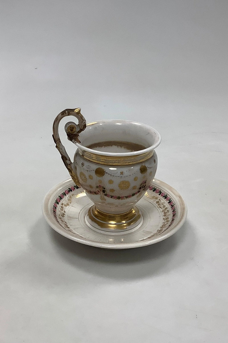 Gammel kop og underkop med dekoration med blomsterguillander og guld