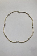 Goldnecklace 14 ct made of 8 slightly curved segments divided by pearls.