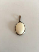 N.E. 从纯银骨质项链的吊坠。