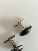 タイガーアイをあしらったシルバーのオーバルカフリンクス。