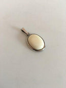 N.E. 从纯银骨质项链的吊坠。