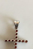 Pendant in 18 K. White gold shaped like cross with 16 red stones