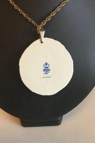 Royal Copenhagen Vedhæng a fporcelæn med gulddekoration. Designet af Nils Thorson. Sterling sølv af Anton Michelsen