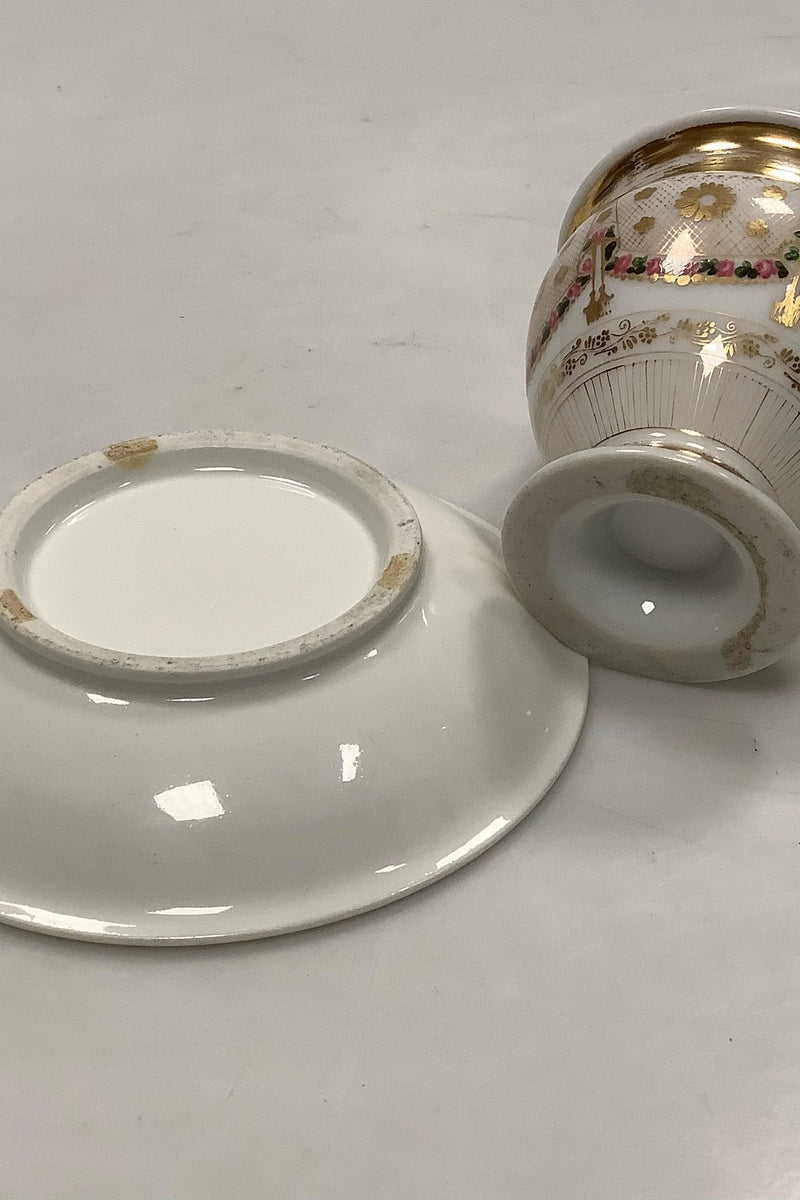 Gammel kop og underkop med dekoration med blomsterguillander og guld