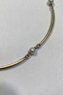 Goldnecklace 14 ct made of 8 slightly curved segments divided by pearls.