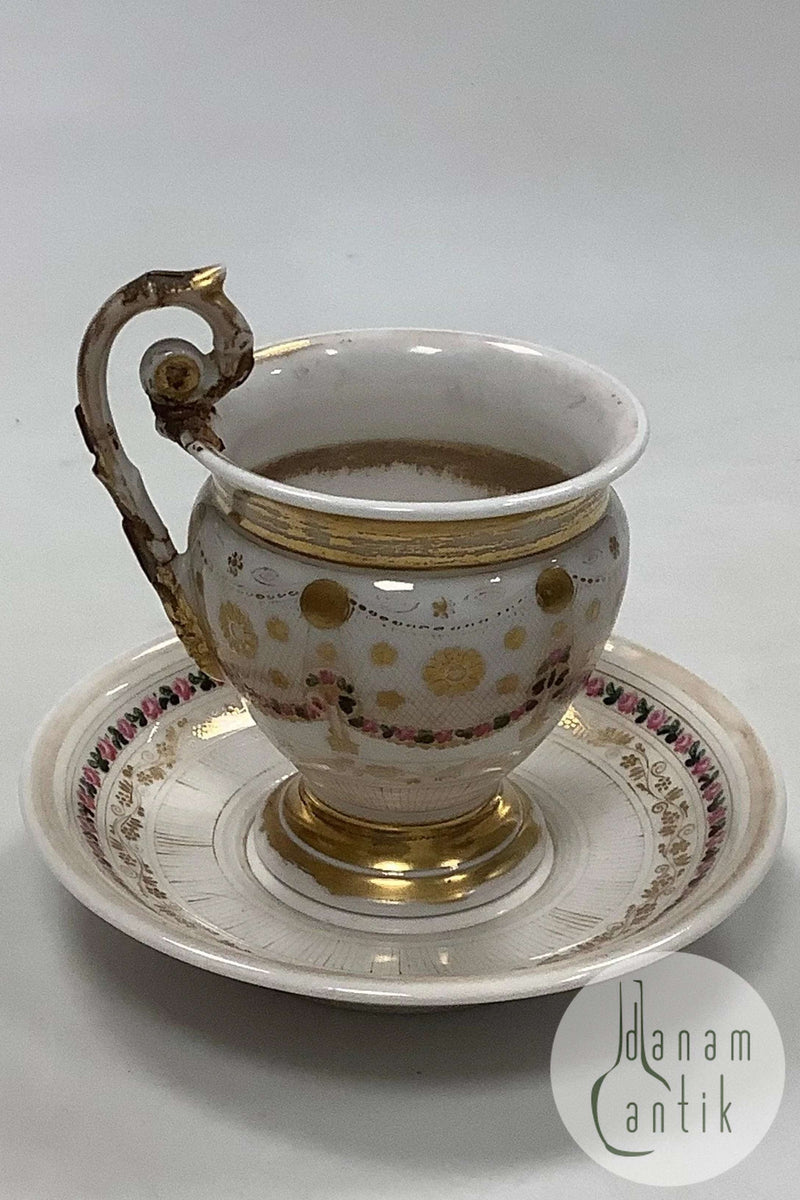 Gammel kop og underkop med dekoration med blomsterguillander og guld