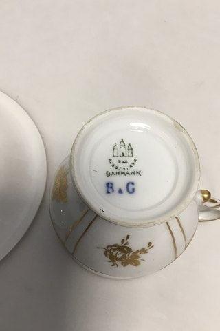 Bing & Grøndahl kop og underkop i guld og polykrom overglasur med blomstermotiv. - Danam Antik