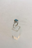 Ring i 14 K Hvidguld med Blå sten(Safir) to Brillanter omkranset af 16 små sten. - Danam Antik